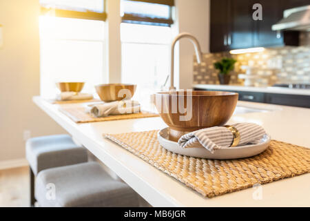 Ciotola di legno posto impostazioni sull Isola per cucina astratta. Foto Stock