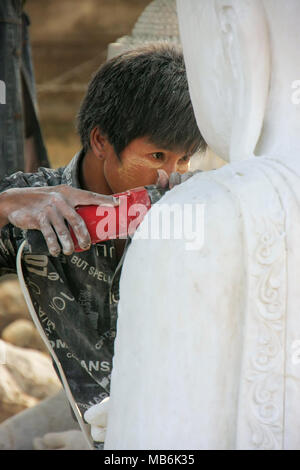 Locali di uomo che lavora su una statua vicino Mahamuni Pagoda di Mandalay, Myanmar. Mandalay è la seconda più grande città in Myanmar. Foto Stock