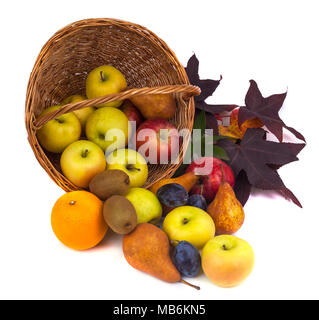 Mele e altri frutti in un cesto di vimini su uno sfondo bianco. Foto Stock