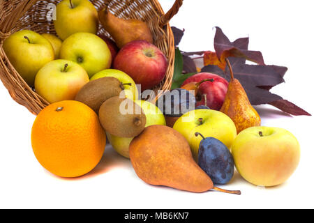 Mele e altri frutti in un cesto di vimini su uno sfondo bianco. Foto Stock