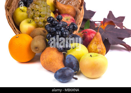 Mele e altri frutti in un cesto di vimini su uno sfondo bianco. Foto Stock