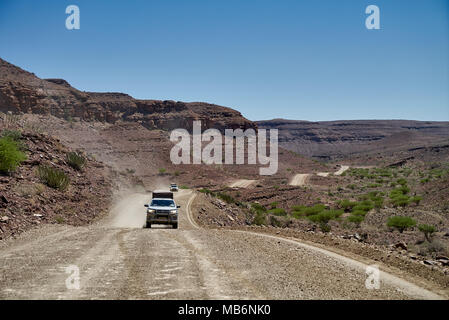 I turisti in auto 4x4 su un self-drive viaggio sulla strada di ghiaia attraverso rocce deserte paesaggio di montagna nel sud della Namibia, Africa Foto Stock
