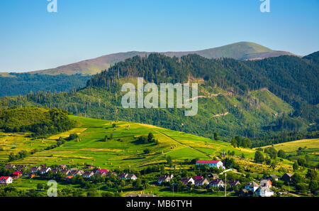 Area rurale nelle montagne al tramonto. incantevole paesaggio estivo della città Volovets, Ucraina. montagna Verkh Velykyi è visto in lontananza Foto Stock