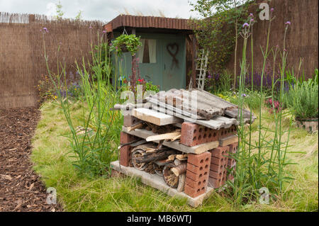 Bug hotel fornendo habitat naturale per la fauna selvatica, fiori selvatici e tettoia in legno - "Home Sweet Home" mostra il giardino - RHS Flower Show, Tatton Park, Inghilterra, Regno Unito. Foto Stock