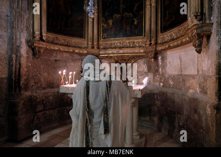 Un Ortodossa Etiope pellegrino cristiano pregare presso la cappella Greca di San Longino il centurione romano che hanno trafitto di Cristo e convertito al cristianesimo all interno della chiesa del Santo Sepolcro la Città Vecchia di Gerusalemme Est Israele Foto Stock