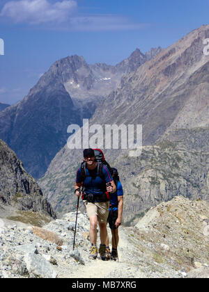 Tall atletico scalatore maschio sull'approccio escursione in remoto a un campo base in francese ASlps Foto Stock