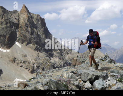 Tall atletico scalatore maschio sull'approccio escursione in remoto a un campo base in francese ASlps Foto Stock