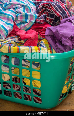 Piena grande cesto in plastica colorati lavanderia a secco Foto Stock