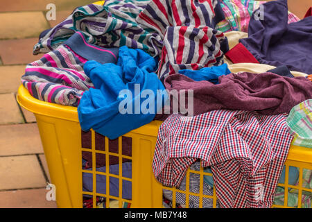 Piena grande cesto in plastica colorati lavanderia a secco Foto Stock