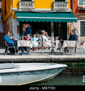 I turisti in una terrazza sul bordo di un canale di Venezia Foto Stock