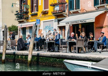 I turisti in una terrazza sul bordo di un canale di Venezia Foto Stock