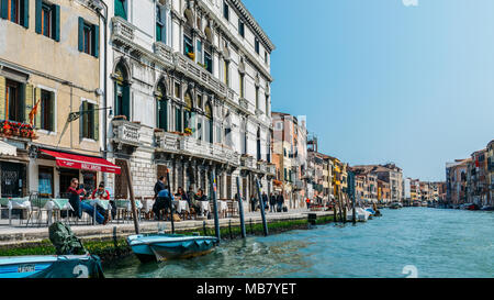 I turisti in una terrazza sul bordo di un canale di Venezia Foto Stock