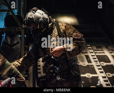 Un U.S. Air Force xvii Special Operations Squadron loadmaster mette sul occhio equipaggi e il sistema di protezione respiratoria (AERPS) attrezzatura nel retro di un U.S. Air Force MC-130J Commando II Gen 31, 2018, al largo di Okinawa, in Giappone. Xvii sos eseguite in-flight training con attrezzature AERPS come parte integrante delle normali possibilità di sopravvivere e di funzionare (ATSO) formazione. (U.S. Air Force Foto Stock