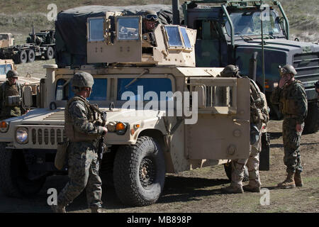 Stati Uniti Marines dal 1° aria Naval spari Liaison Company, 1° Marine forza expeditionary, consegnare le forniture al primo Stryker Brigade Combat Team, seconda divisione di fanteria, durante l'esercizio #BayonetFocus 18-02 a Camp Roberts, California, Febbraio 7, 2018. L'esercizio consente di Marines e soldati per creare coesione e sviluppare una comune comprensione delle funzionalità e limitazioni in un aggressivo e complesso ambiente di minaccia. Marines dal 1° ANGLICO comandanti di fornire una capacità di collegamento per pianificare, coordinare e condurre il terminale controllo degli incendi a sostegno del giunto, alleati e le forze della coalizione. Foto Stock