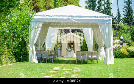 Luogo decorativo per cerimonie o di intrattenimento. Ricevimento all'aperto sotto le tende e alberi Foto Stock