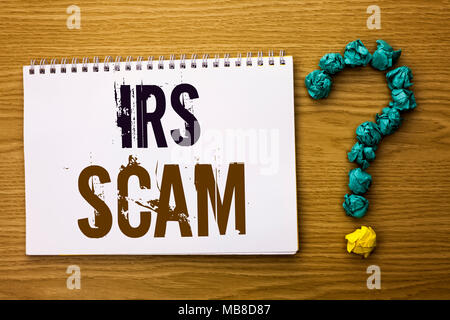 Segno di testo mostra Irs truffa. Foto concettuale truffa Avviso di frode fiscale Spam Pishing denaro entrate schema di avviso scritto libro Notebook il backgroun di legno Foto Stock