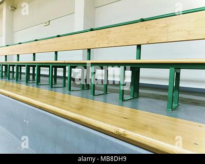 Svuotare posti a sedere in legno in uno stadio sportivo. Tribune per gli appassionati di fiammiferi vuote con panche di legno. Foto Stock