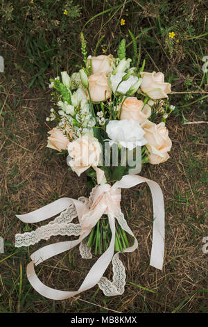 Bouquet di nuziale fiori sul terreno in legno. Stile rustico di elementi di arredamento. Vista superiore verticale foto a colori. Foto Stock