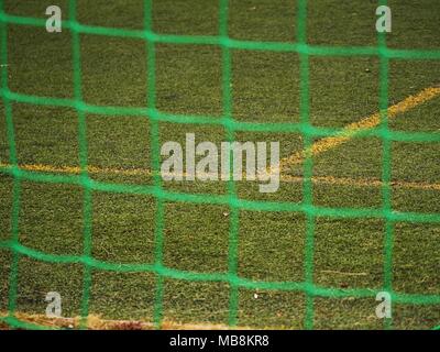 Close up dettaglio di un calcio net contro erba verde in un giorno nuvoloso. Messa a fuoco selettiva Foto Stock