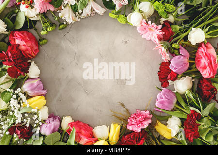 Vista dall'alto di fiori romantici disposti in un cerchio su sfondo grigio. Il giorno di San Valentino bouquet concept Foto Stock