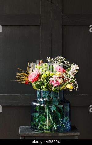 Grande mazzo di fiori in un vaso di vetro su sfondo nero. La festa della mamma regalo concept Foto Stock