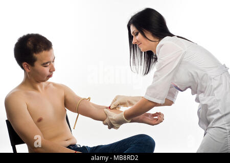 Un medico donna iniezioni in vena o richiede un esame del sangue dalla vena della mano del paziente di East Asian aspetto. Foto Stock