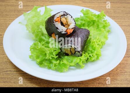 La cucina giapponese, Vagetarian tradizionale di riso giapponese maki sushi Roll roba con tofu e carote avvolte in Nori alghe servita sulla quercia verde. Foto Stock