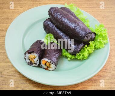 La cucina giapponese, Vagetarian tradizionale di riso giapponese maki sushi Roll roba con tofu e carote avvolte in Nori alghe servita sulla quercia verde. Foto Stock