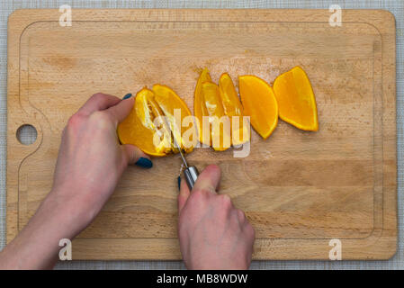 Arancio tagliato su una tavola di legno Foto Stock