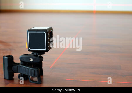 Forma cubica cross-linea laser sul pavimento con le linee del laser. Costruzione e ristrutturazione Concetto di immagine con una stanza per il testo. Foto Stock