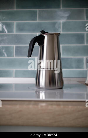 Un inossidabile geyser con macchina per il caffè è sulla stufa elettrica. Foto Stock
