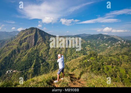 Ritratto orizzontale di un turista di scattare le foto di Ella Rock da poco di Adamo nel picco Ella, Sri Lanka. Foto Stock