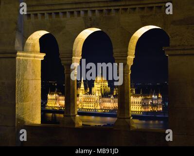 Parlamento ungherese attraverso il bastione dei pescatori di portici, Budapest. Foto Stock