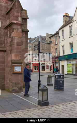 Un uomo in attesa presso l'angolo di strada accanto alla chiesa di San Giovanni Evangelista un sabato pomeriggio in primavera a Perth, Perthshire Scozia. Foto Stock