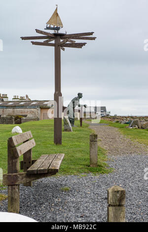 Una statua di un pescatore guarda al mare nel villaggio di Port William che è situata nella parrocchia di Mochrum, Dumfries and Galloway, Scozia. Foto Stock