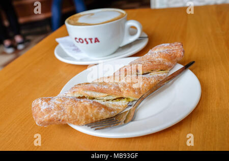 Tazza di caffè Costa cappuccino e cioccolato pasticceria di torsione Foto Stock