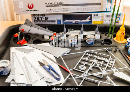 In Inghilterra. Hasagawa Boeing aereo kit hobby, modello pezzi disposti su workbase con vernici, spazzole e altri strumenti durante la fase di verniciatura e assemblaggio. Foto Stock