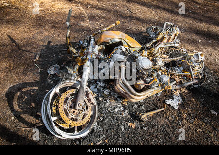 Bruciò motociclo dopo un incidente sdraiato Foto Stock