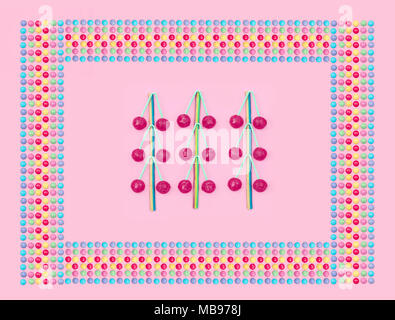 Un assortimento di caramelle colorate su sfondo rosa. Foto Stock