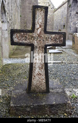 La lapide in pietra con croce in rovine di Clare Abbey in Irlanda. Foto Stock