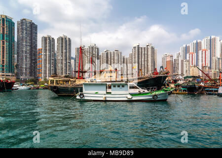 Edifici alti offrono lo sfondo per le barche dei pescatori di Aberdeen Harbour, Hong Kong. Foto Stock