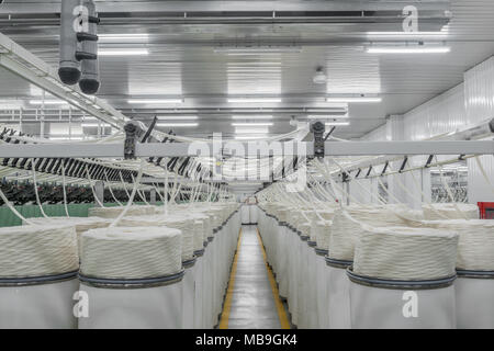 Macchinari e attrezzature in officina per la produzione di filato, panoramica. interno di industriale fabbrica tessile Foto Stock