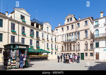 Campo Santa Marina e Hotel Santa Marina, Castello, Venezia, Veneto, Italia con un gruppo di tour gatheredd attorno a un pozzo o bene la testa e news stand Foto Stock