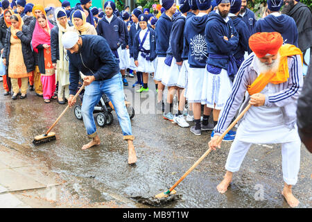 Southall, Londra, 8 aprile 2018. La strada è spazzato e pulito, molti partecipanti hanno rimosso le loro scarpe in onore del guru. I sikh in London celebrare Vaisakhi, la nascita dei khalsa e la festa della mietitura con l annuale Southall Vaisakhi processione (nagar kirtan) da Havelock Road Gurdwara al Park Avenue Gurdwara. Vaisakhi giorno stesso sarà in aprile 14th. Credito: Imageplotter News e sport/Alamy Live News Foto Stock