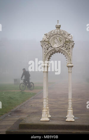 Warrington, Cheshire, Regno Unito. Il 9 aprile 2018. In una nebbiosa mattina di lunedì, 9 aprile 2018, un ciclista passeggiate attraverso la Queen's Gardens in Warrington, Cheshire, Inghilterra, UK per il suo modo di lavorare Credito: John Hopkins/Alamy Live News Foto Stock