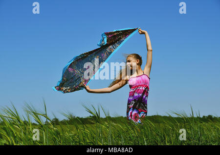 Bella bruna ragazza in piedi sul campo verde Foto Stock