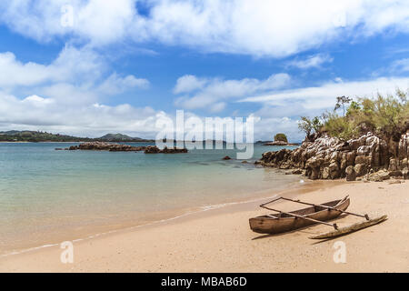 Una tipica canoa outrigger spiaggiata su Nosy Sakatia (Nosy Be), Madagascar Foto Stock