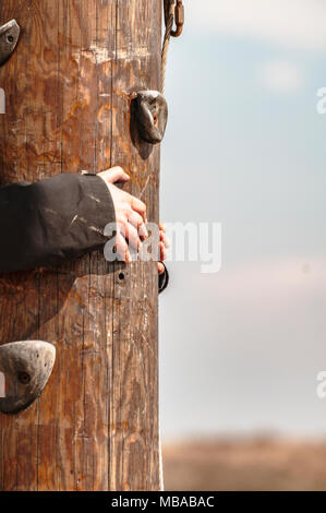 Due mani abbracciare uno spesso posto di legno Foto Stock