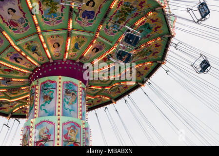 Vista laterale della filatura Luftikus giostra o catena corsa di oscillazione a nuvoloso giorno, parco divertimenti Prater Foto Stock