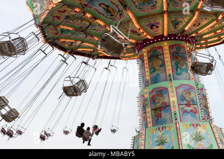 Vista laterale della filatura Luftikus giostra o catena corsa di oscillazione a nuvoloso giorno, parco divertimenti Prater Foto Stock